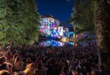 A crowd pf people watching a light show projected on Snežnik Castle.